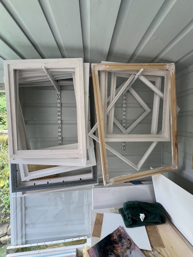 Wooden stretcher bars and empty frames leaning against the studio wall